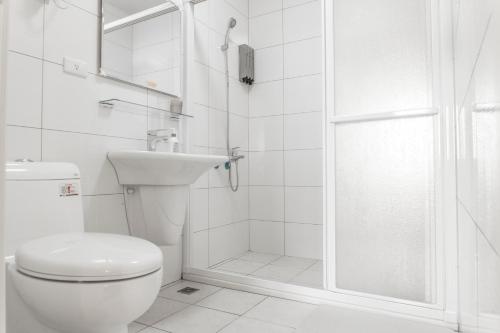 a white bathroom with a toilet and a shower at Beyond Home in Jiaoxi