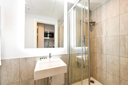a bathroom with a sink and a glass shower at Argyl - The Apiary, Ealing in Ealing