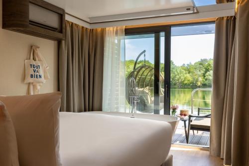 a bedroom with a tub and a view of a patio at L'Escale Royale Torcy - Marne la Vallée in Torcy
