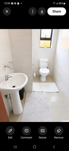 a bathroom with a white sink and a toilet at Duco self-catering in Nelspruit