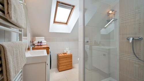 a white bathroom with a shower and a sink at Villa Dobrenic by Villas Guide in Donje Taborište