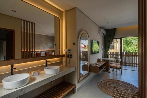 a bathroom with two sinks and a large mirror at Be Caju Hotel in Barra Grande