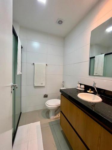 a bathroom with a sink and a toilet and a mirror at Westfit Barreto 01 in Mossoró