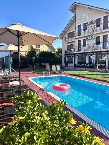 a swimming pool with a red frisbee in front of a building at Pensiunea Tirol Baile Felix in Baile Felix