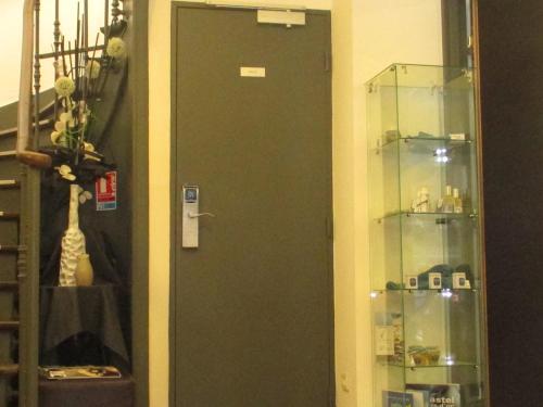 a green door in a room with a shelf at Hôtel le Pastel in Toulouse