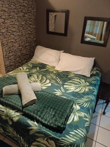 a bed with a green blanket and towels on it at Skaap Kraal Guest Farm in Kakamas