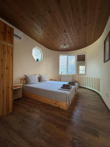 a bedroom with a large bed with a wooden ceiling at Guest house LORA in Gabrovo