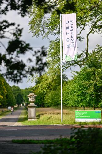 a white flag on a pole next to a street at Hotel Heemskerk in Heemskerk