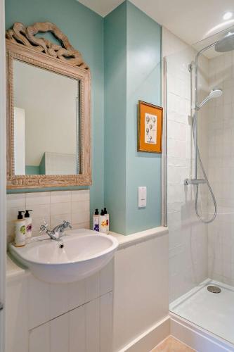 a bathroom with a sink and a shower with a mirror at Tiger Inn - Elizabeth in Eastbourne
