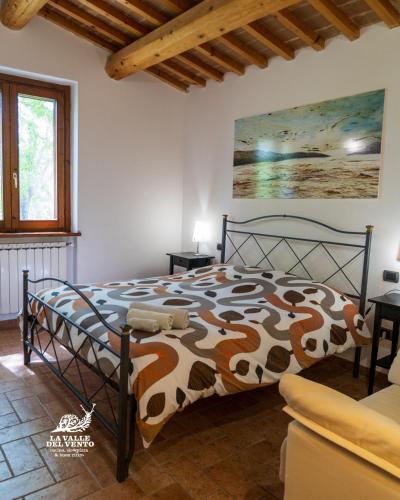 a bedroom with a bed with a cow print comforter at Agriturismo La Valle del Vento Urbino in Urbino