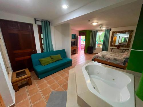 a living room with a tub and a bed at Kaa Zihil Hotel in Playa del Carmen