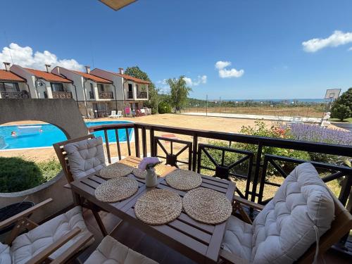 a patio with a table and chairs and a pool at Sweet home see view pool escape in Nesebar