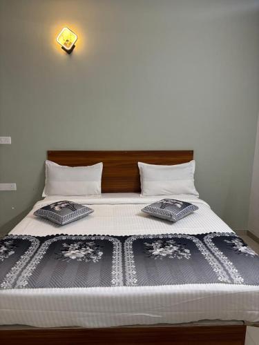 a bed with two pillows on top of it at Hoysal Grand in Bangalore