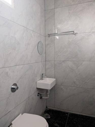 a bathroom with a toilet and a sink at Hoysal Grand in Bangalore