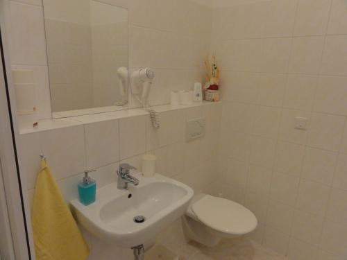a white bathroom with a sink and a toilet at Penzion U Hradeb in Znojmo