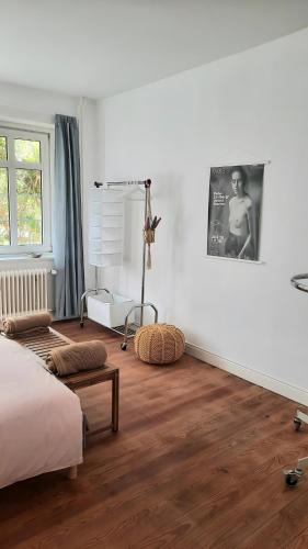 a bedroom with white walls and a bed and wooden floors at Altbauvilla nahe Schlosspark in Eutin
