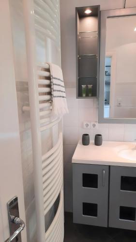 a white bathroom with a sink and a mirror at Altbauvilla nahe Schlosspark in Eutin
