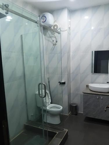 a bathroom with a shower with a toilet and a sink at Emirates Star Hotel & Suites in Asaba
