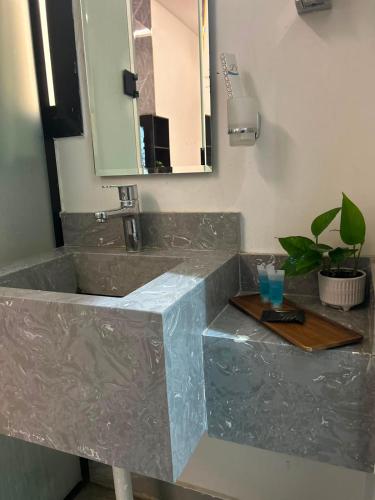 a bathroom with a marble sink and a mirror at شقق كالم للشقق المخدومة 1 in Riyadh