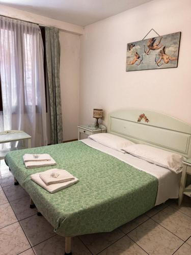 a bedroom with a bed with towels on it at Hotel Adua in Venice