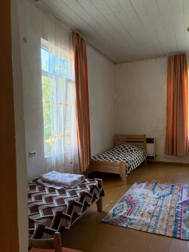 a room with two beds and a window at Nikola apartment ambrolauri in Ambrolauri