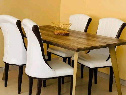 a wooden table with four white chairs around it at Kalahari in Sekoma