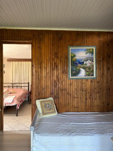 a bedroom with a bed and a painting on the wall at Real Holidays Antoniadou - Rustic House in Elaiokhórion