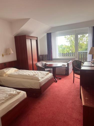 a hotel room with two beds and a table at Hotel Seeblick garni in Gartow