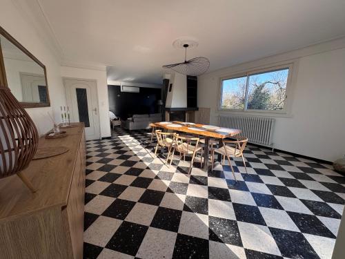 a living room with a table and a checkered floor at Maison rénovée Montélimar in Montélimar