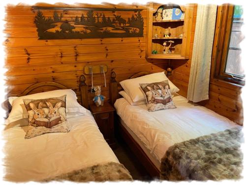 a bedroom with two beds in a log cabin at Blelham Tarn Rustic cabin in tranquil woodland in Ambleside
