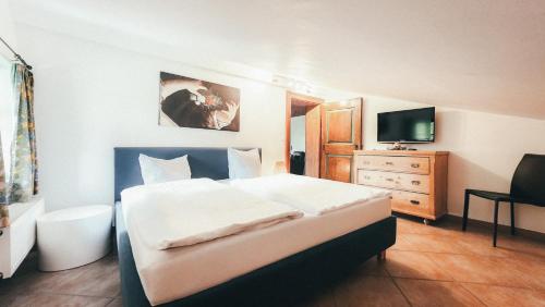 a bedroom with a large bed and a television at Luna Mia Apartment 4 in Schwangau