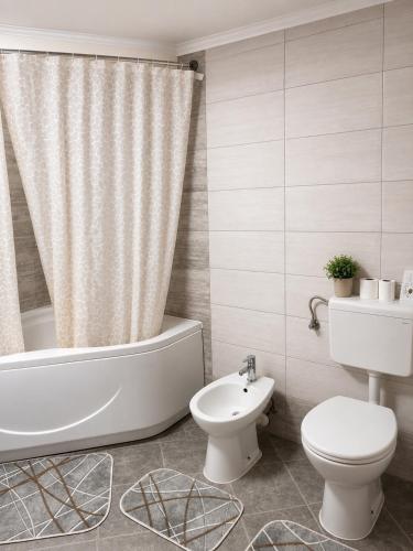 a bathroom with a tub and a toilet and a sink at Little Farm Nani in Visoko
