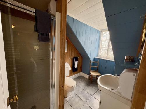 a bathroom with a toilet and a sink and a staircase at Maison Hovington in Tadoussac