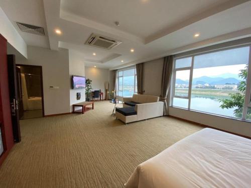 a hotel room with a bed and a large window at Khách sạn APPLAZA in Hòa Bình