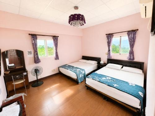 two beds in a room with two windows at Du Du Hao B&B in Yung-an-ts'un