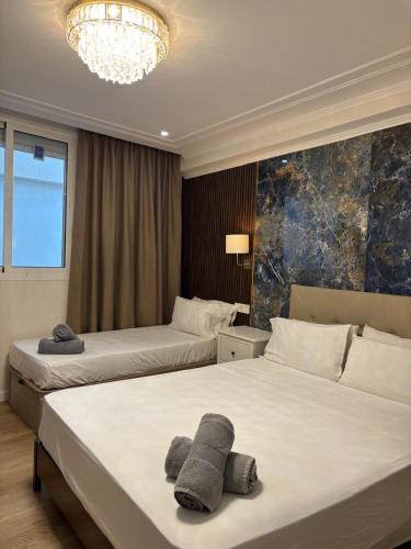 a hotel room with two beds and a chandelier at Costa Marbella Star Light in Marbella