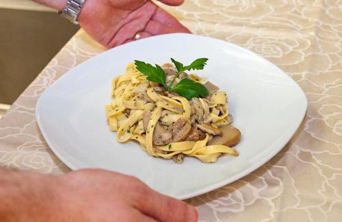 a plate of pasta with meat and vegetables on a table at Hotel Ambra in Clusone
