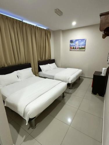a room with two beds in a room with a window at Hotel Lean Fatt in Ipoh