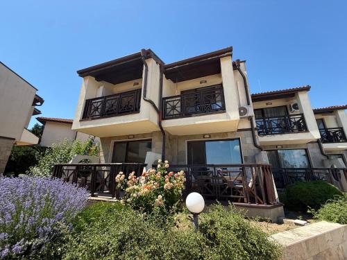 a building with balconies and flowers in front of it at Sweet home see view pool escape in Nesebar