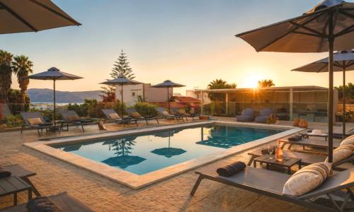 a pool with chairs and umbrellas at a resort at Pranvera Villa Sea View & Pool in Dhrámia