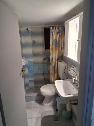 a bathroom with a toilet and a sink at Porto Beach Apartment in Makry Gialos