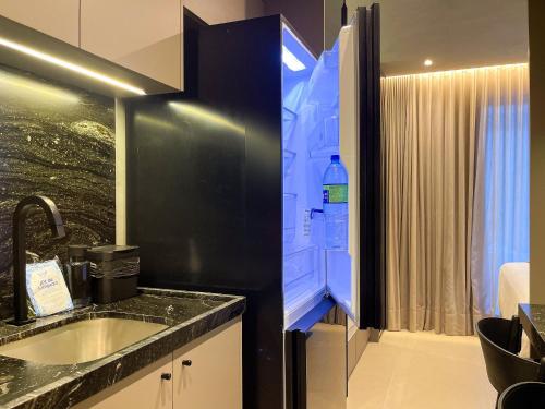 a bathroom with a sink and a black refrigerator at Way Bossa in João Pessoa