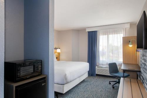 a hotel room with a bed and a television at Garner Hotel Sumter Northwest in Sumter