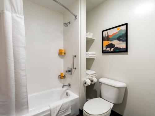 a white bathroom with a toilet and a shower at Gray Wolf Inn & Suites in West Yellowstone