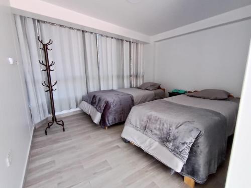 a bedroom with two beds and a large window at Sr de Huanca in Mollepata