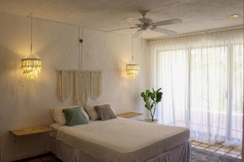 a bedroom with a bed and a ceiling fan at Ocean Bloom in Cancún