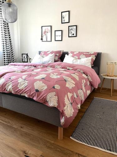 a bedroom with a bed with a pink comforter at Lichte Wohnung zum Wohlfühlen in Bastheim