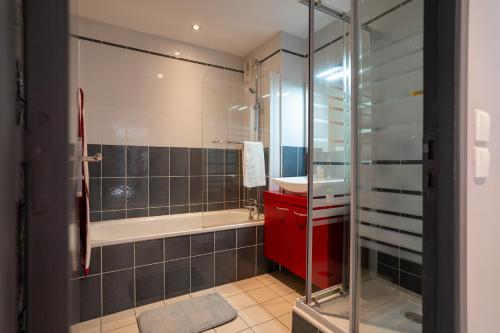 a bathroom with a shower and a tub and a sink at Plage Centrale in Soorts-Hossegor