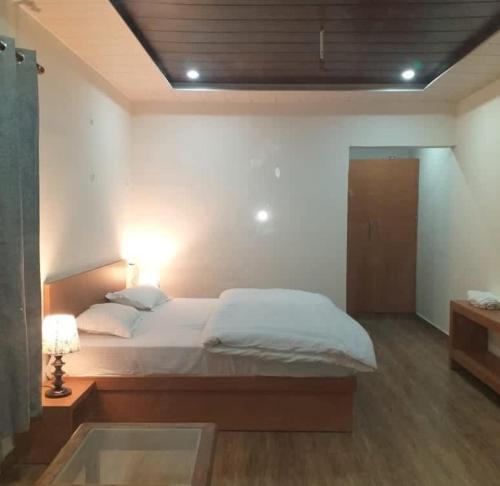 a bedroom with a large bed and a window at Dayara resort in Bhatwāri