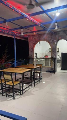 a room with two tables and chairs and a kitchen at Island Hospitality in Himandhoo 
